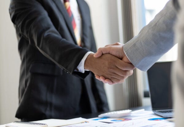 A client shaking hands with a lawyer at the start of a legal consultation.