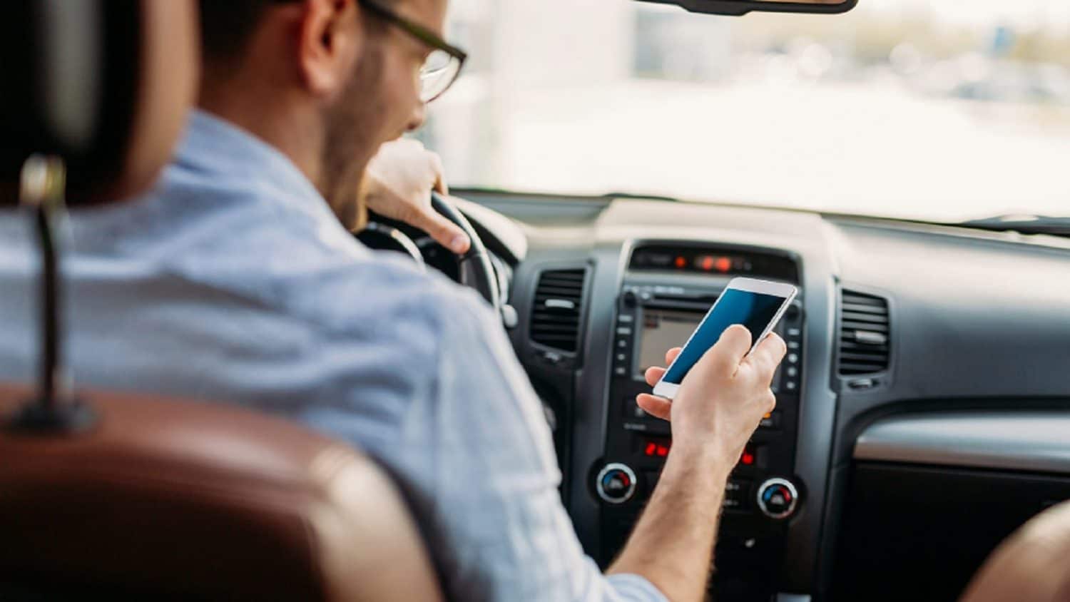 Young Man Texting While Driving His Vehicle Stock Photo
