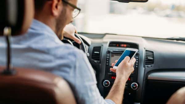 Young Man Texting While Driving His Vehicle Stock Photo