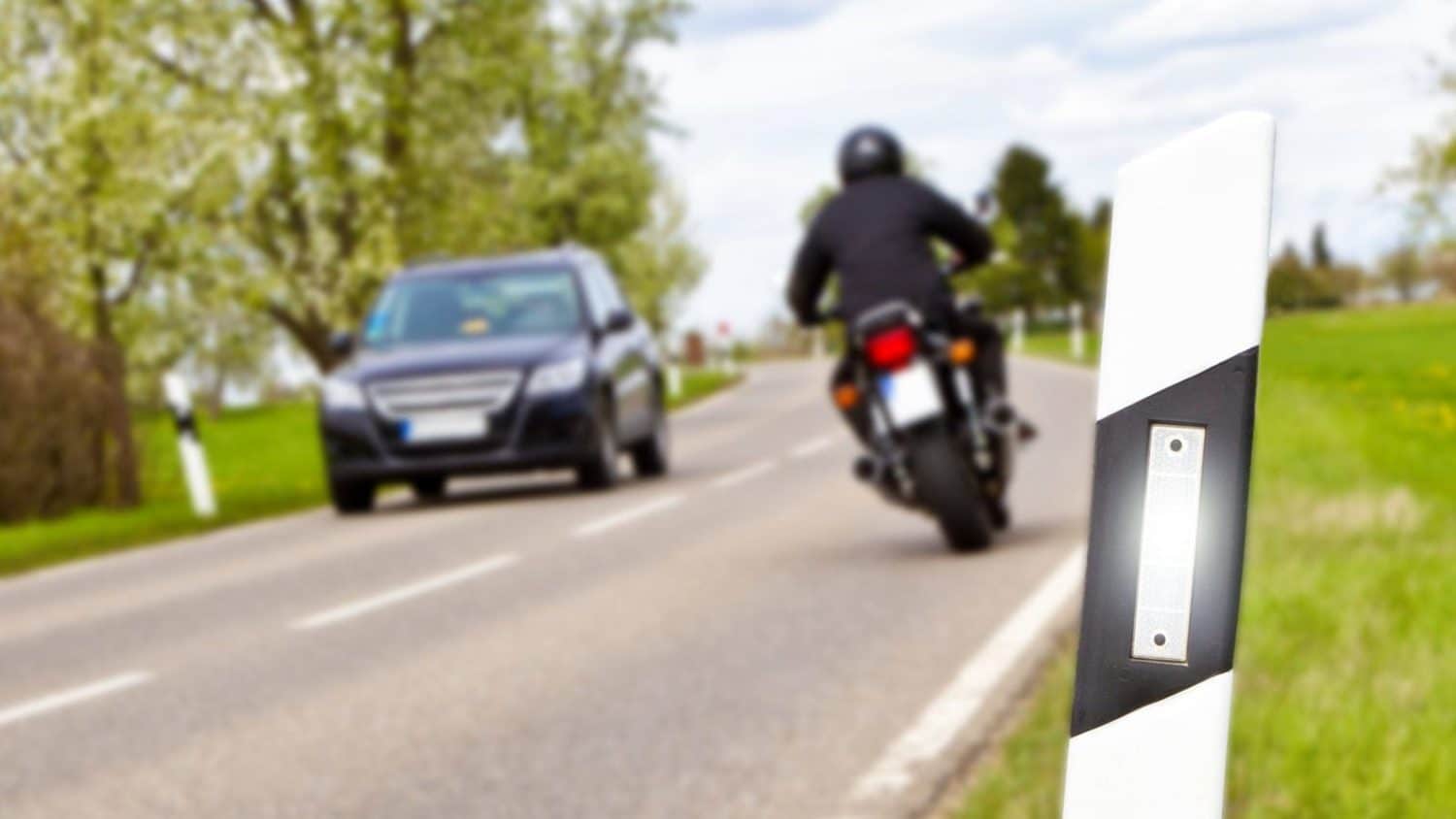 Motorcyclist Passing A Car On A Rural Road 