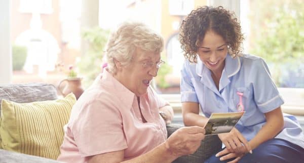Nurse Spending Time With Elderly Resident At Nursing Home
