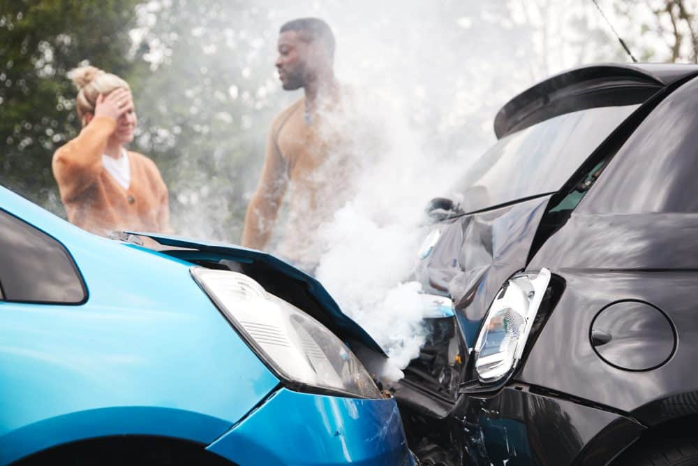 Two drivers looking at the damage after a car accident in Chattanooga.