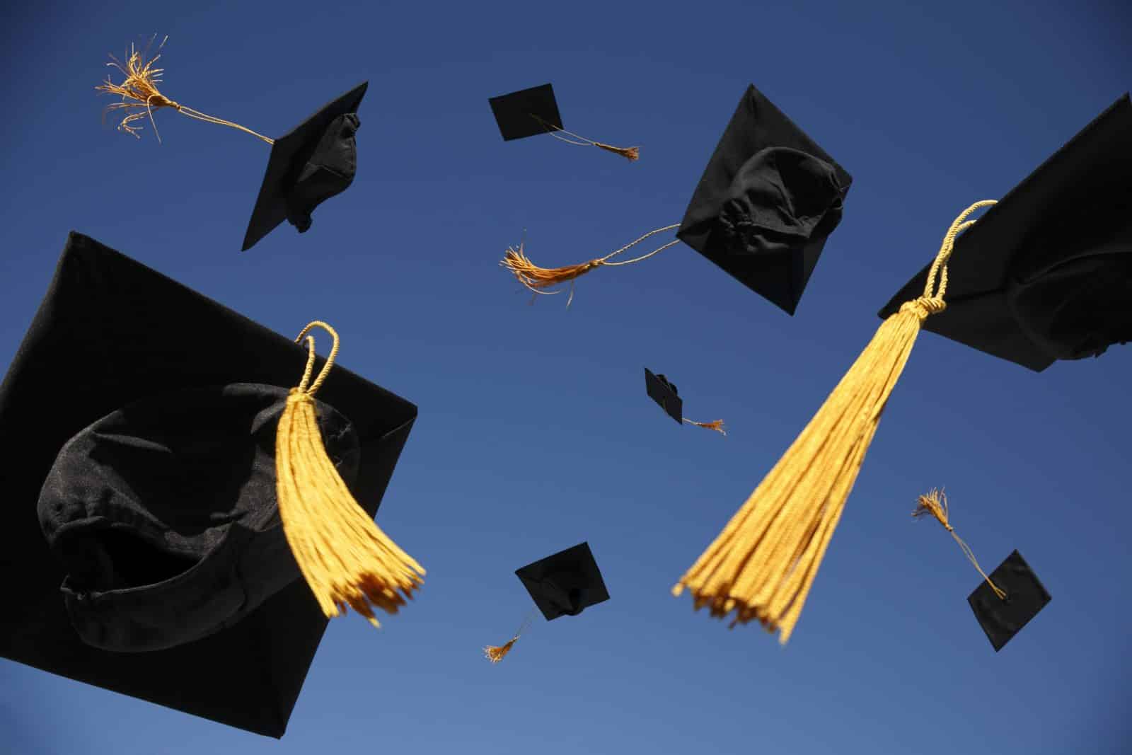 Graduation caps tossed in the air.