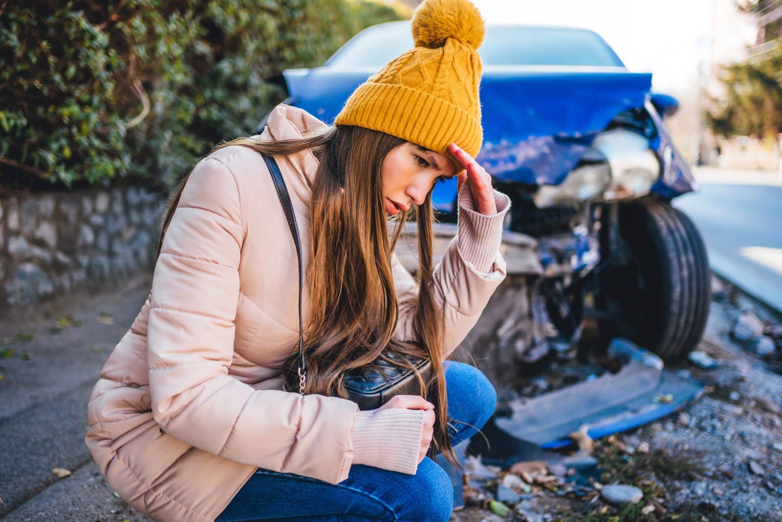 A worried woman sits in front of her damaged car after an accident in Chattanooga.