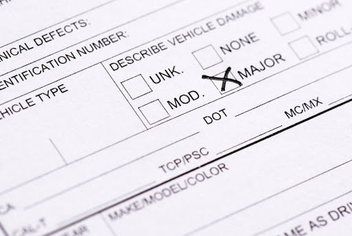 A portion of a motor vehicle accident report is seen, noting “MAJOR” vehicle damage.